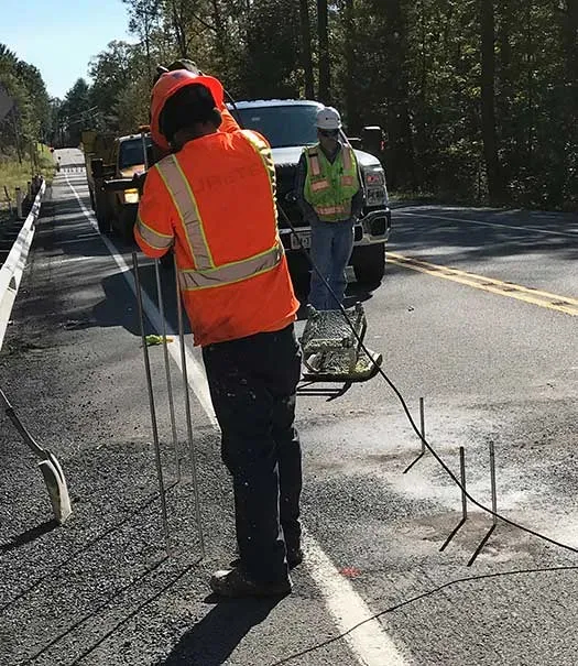 URETEK technician installing tube in highway