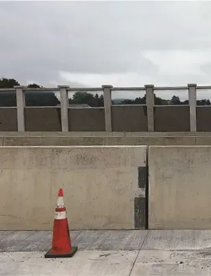 Construction cone by highway wall