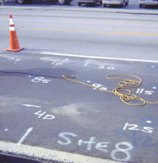 Construction cone on roadway with spray paint markings