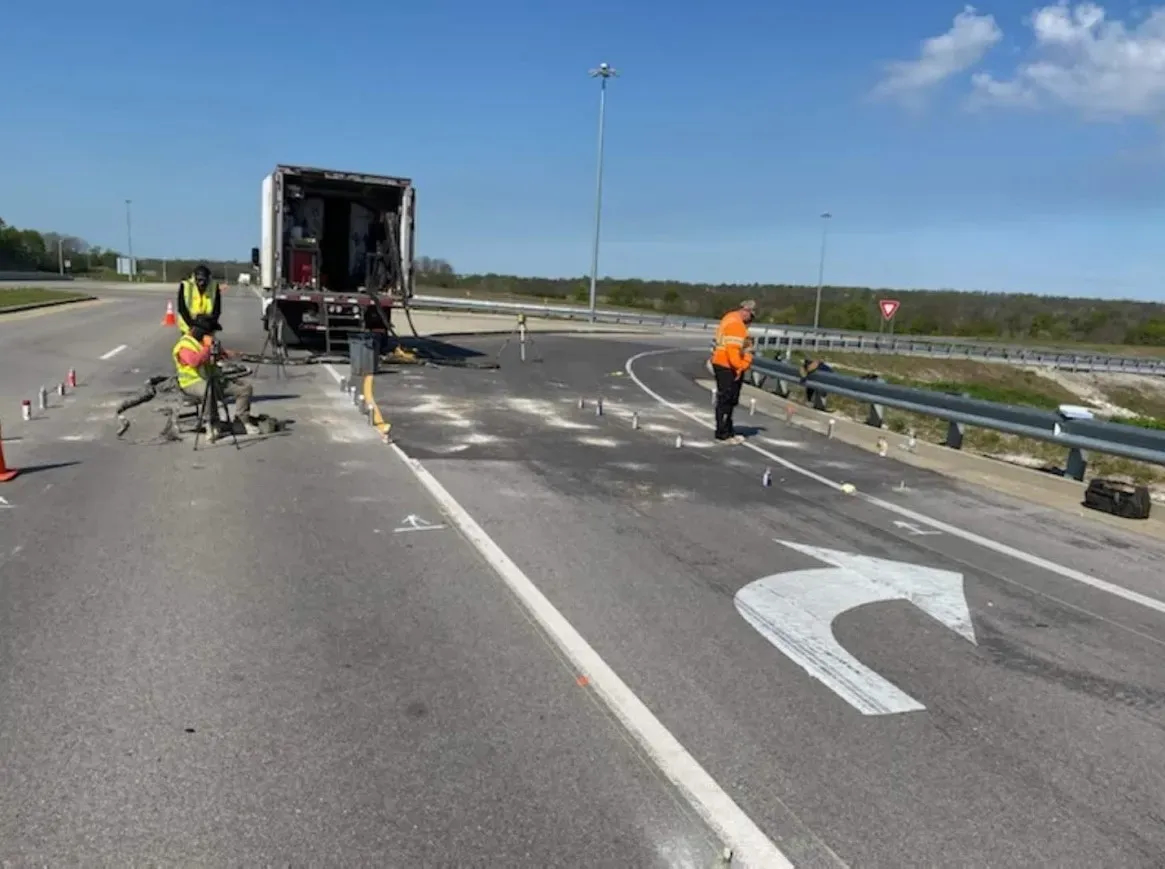 Three URETEK technicians working on highway exit ramp