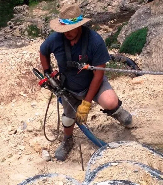 Man in round hat working in sand