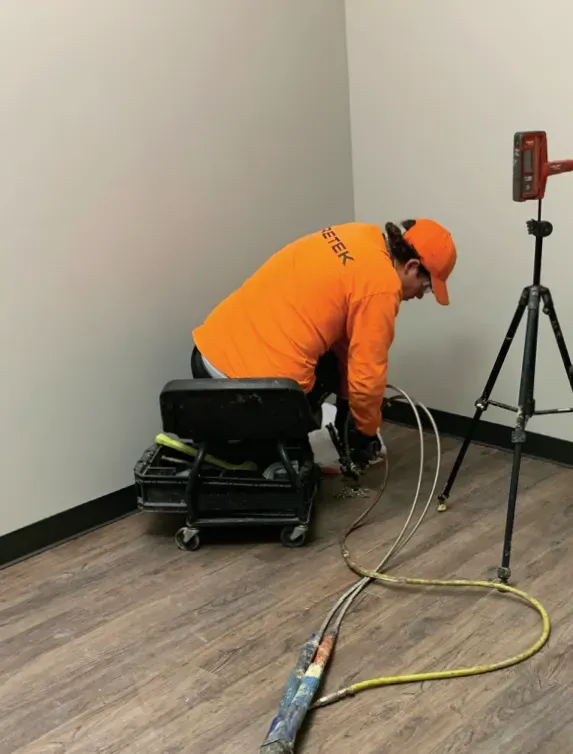 URETEK technician on hardwood floor interior