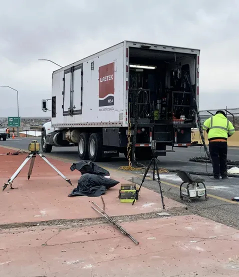 Technician conducting PCR test behind Large white URETEK semi truck with open back door