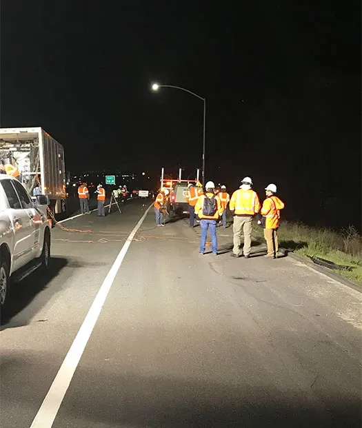 Large URETEK team in conversation at night on roadway